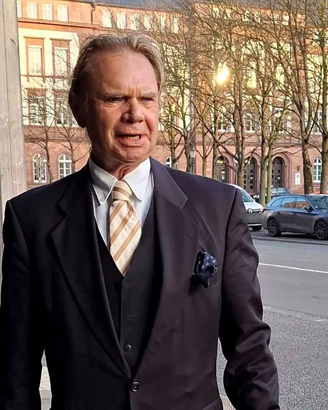 Rechtsanwalt und Notar Walter Schott im Anzug vor einem historischen Gebäude